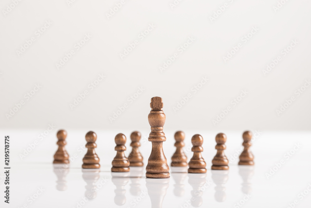 Dark chess pieces standing on white table Dark chess pieces standing on white table