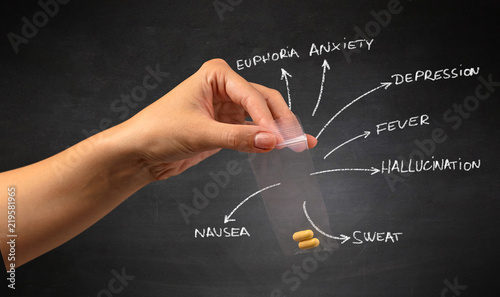 Hand with pills in plastic bag and blackboard wallpaper photo