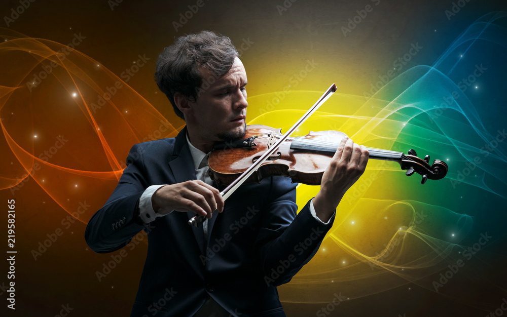 Fototapeta premium Serious classical violinist with fabled sparkling wallpaper