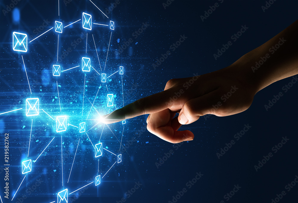 Female finger touching a beam of light surrounded by a blue graphic with envelopes Female finger touching a beam of light surrounded by a blue graphic with envelopes