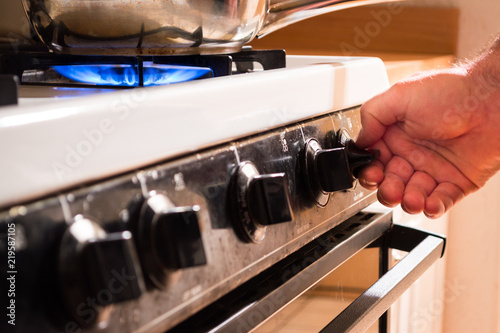 Man turning on burner to cook meal