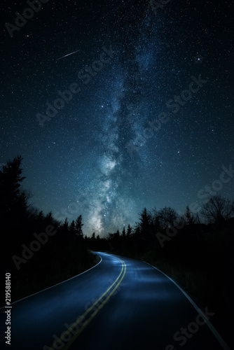 Curvy road with shooting star and Milkyway above