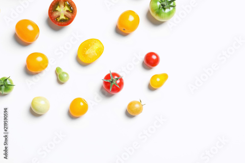 Flat lay composition with different tasty tomatoes on white background