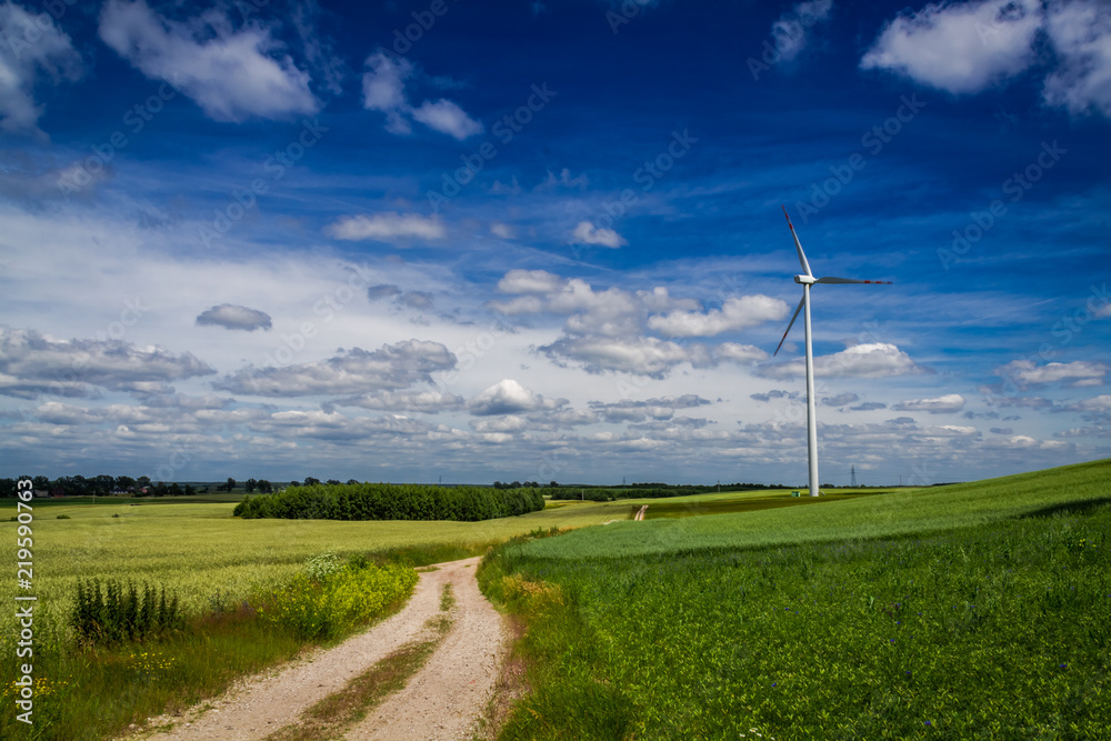 Wind turbines on green field as alternative energy in spring