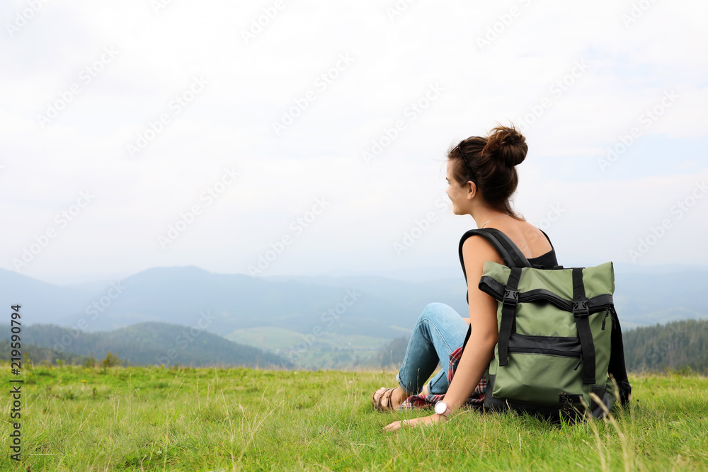 Woman with backpack in wilderness on cloudy day