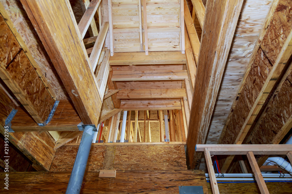 Fototapeta premium wooden beams at construction new residential house framing