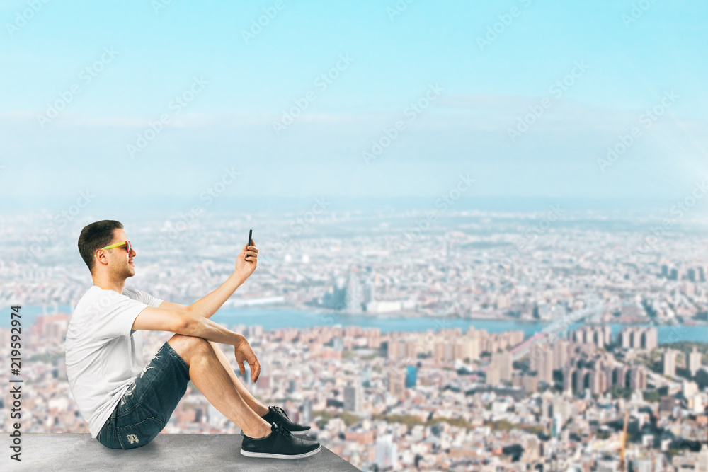 Man with smartphone on rooftop