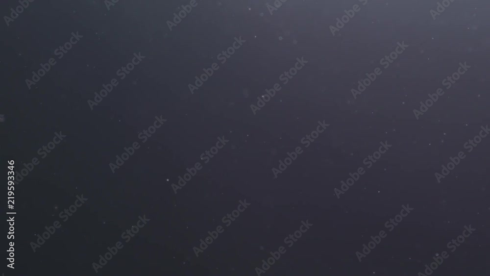Slow motion backlit dust particles floating in the air on a black background with lens flare Slow motion backlit dust particles floating in the air on a black background with lens flare