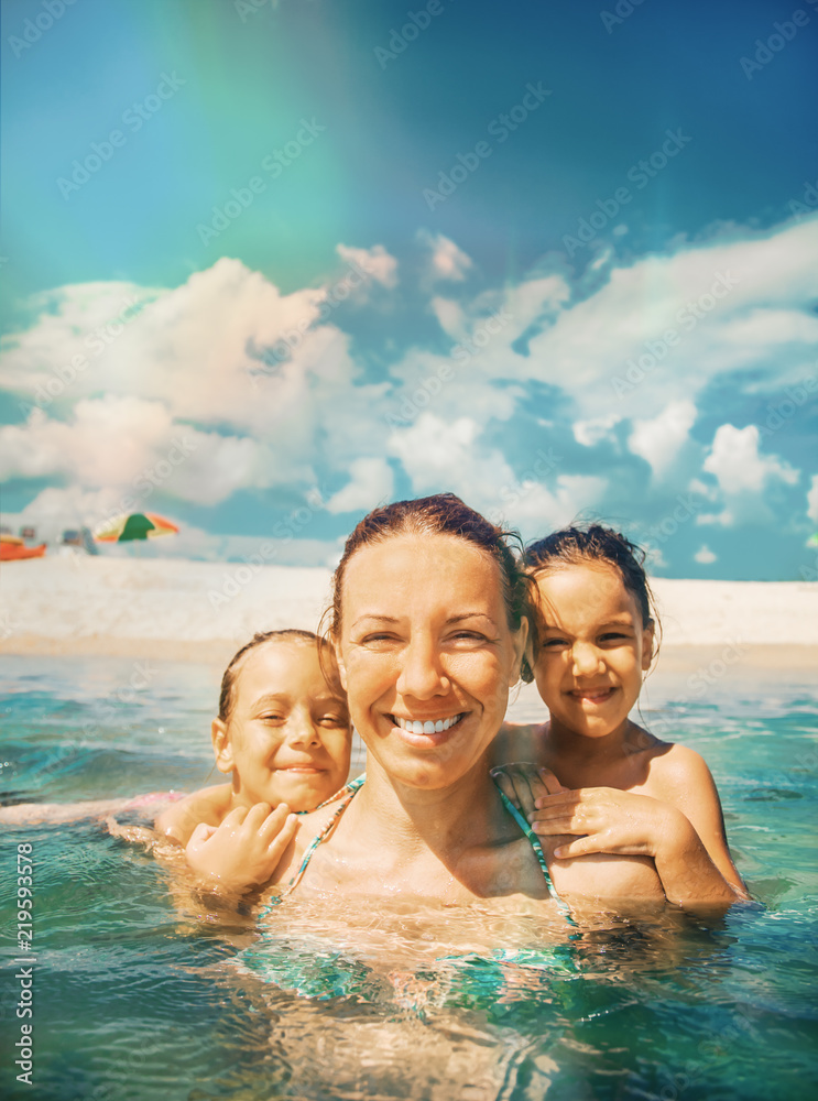 Mother and daughter swim in the shallow sea. They laugh and enjoy on a beautiful beach. Mother and daughter swim in the shallow sea. They laugh and enjoy on a beautiful beach.