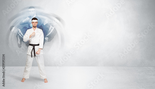 Young businessman in suit fighting with empty wall background 