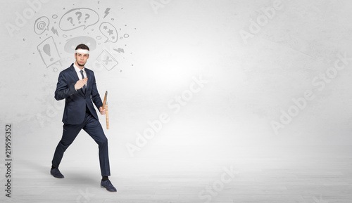 Young businessman in suit fighting with doodled symbols concept   © ra2 studio