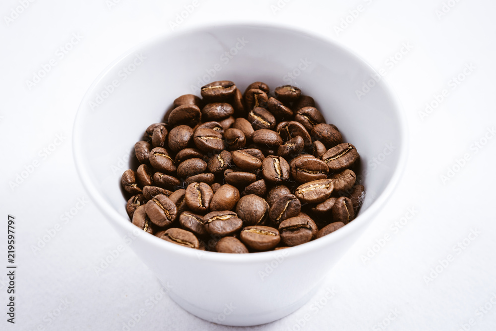 Cup of Coffee Beans roasted on a wooden table with fresh bean with great aroma