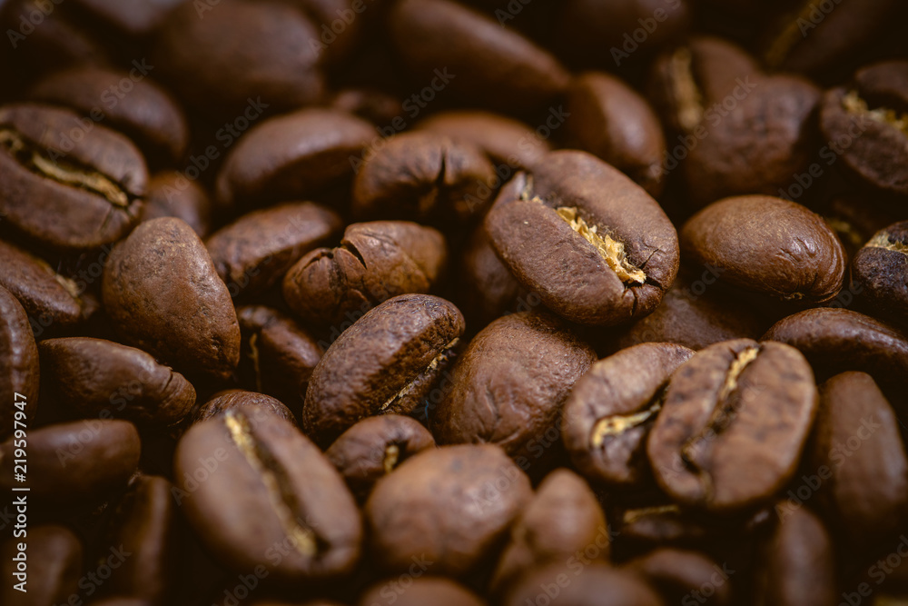 Coffee beans roasted on a wooden table with much of beans with a great aroma Coffee beans roasted on a wooden table with much of beans with a great aroma