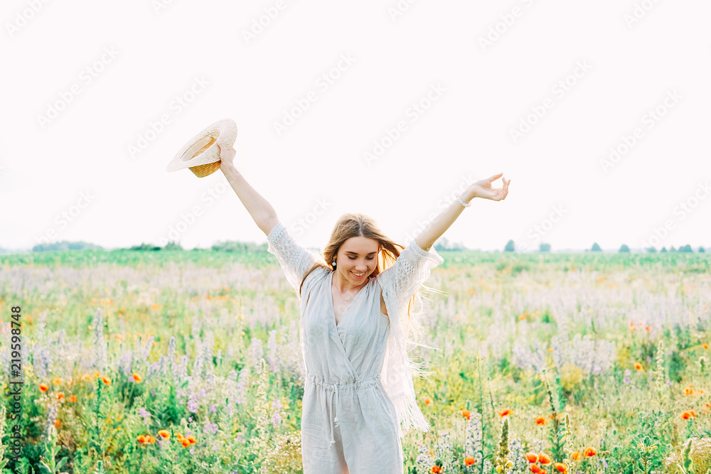 Young countryside girl sitting in the field of poppies Young countryside girl sitting in the field of poppies