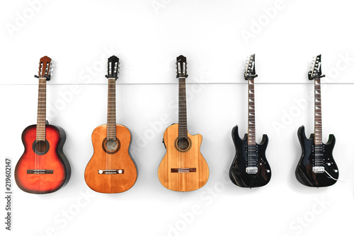 5 Guitars hanging in front of a white wall