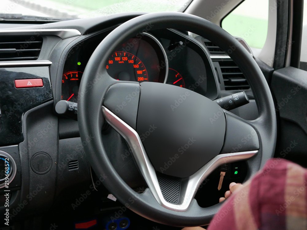 Selective focus of woman hand on steering wheel driving a car with one hand
