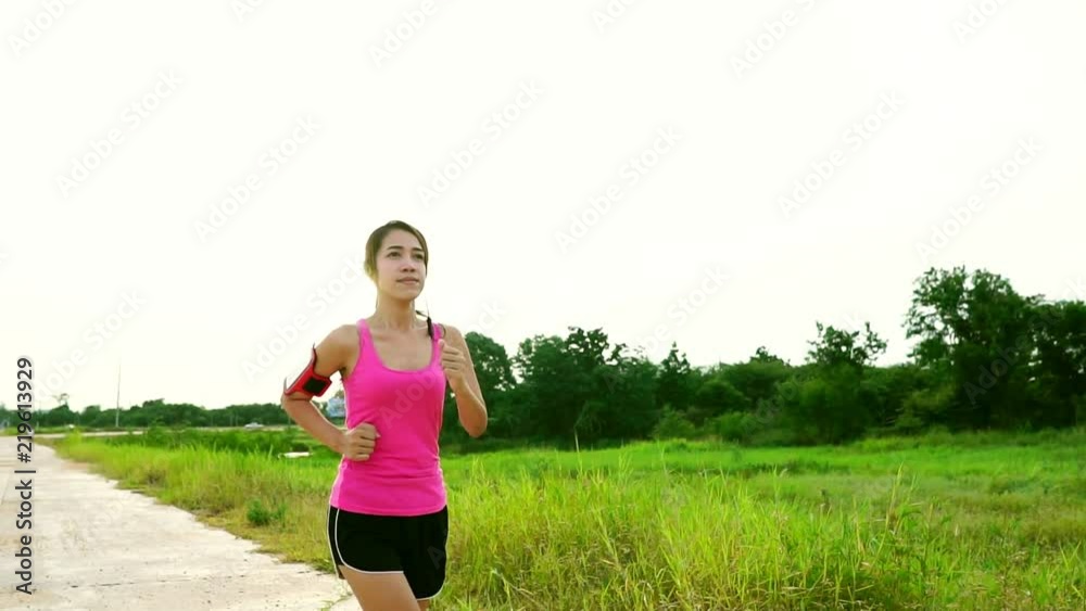 Slow Motion: Woman jogging lightly on the outside of the park Slow Motion: Woman jogging lightly on the outside of the park