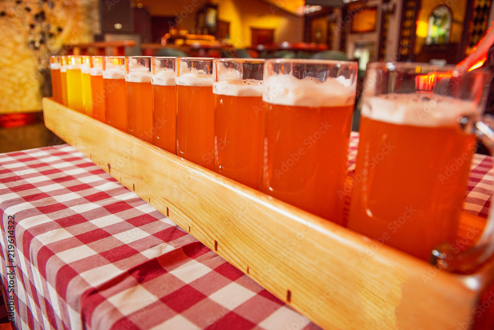 A very large tray with glasses of beer on the table. A very large tray with glasses of beer on the table.