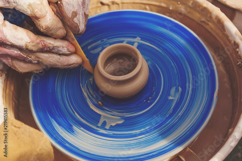 The man - Potter from the clay pitcher on a Potter's wheel. photo