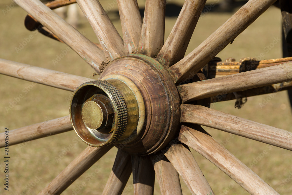 old wooden wheel and sulky bronze in the field old wooden wheel and sulky bronze in the field