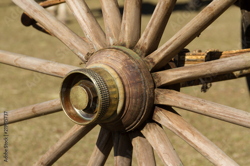 old wooden wheel and sulky bronze in the field