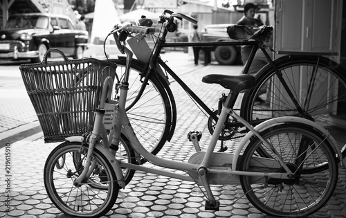 Close up Vintage two Bicycle on cobblestone street in the old town. Color in black and white.