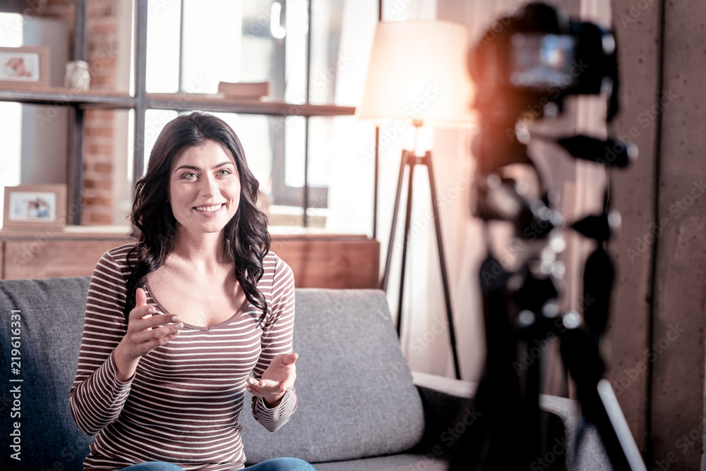 Happy day. Inspired dark-haired woman smiling and making a video for her blog Happy day. Inspired dark-haired woman smiling and making a video for her blog