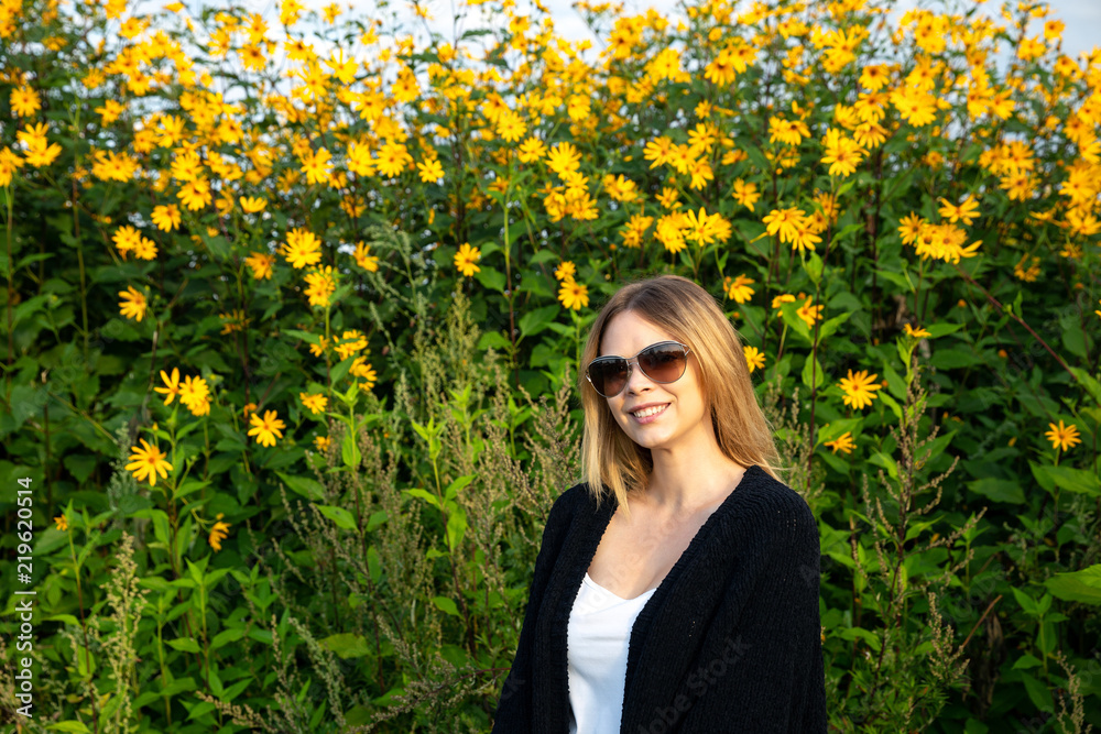The girl stands in yellow flowers. Vacation. Health. Happiness. The girl stands in yellow flowers. Vacation. Health. Happiness.