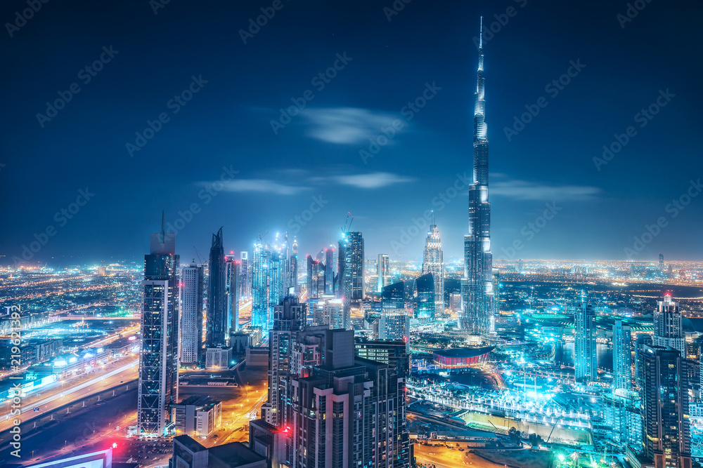 Fototapeta premium Colourful nightime skyline of a big modern city. Dubai, United Arab Emirates. Aerial view on highways and skyscrapers.