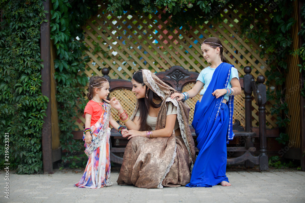 Small children and their mother in traditional Indian attire.