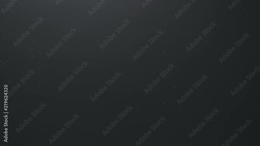 Slow motion backlit dust particles floating in the air on a black background