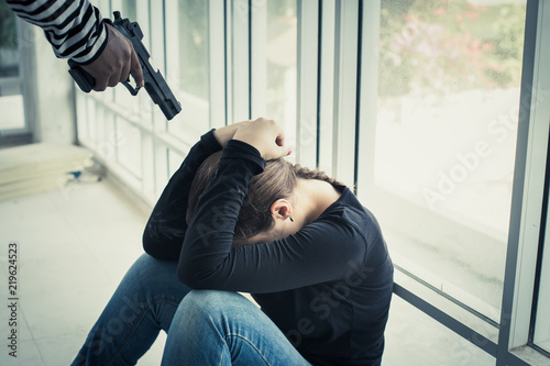 Girl was arrested in an abandoned building by the robbers used a gun to threaten bodily harm.The concept of violence in women. © Sumala