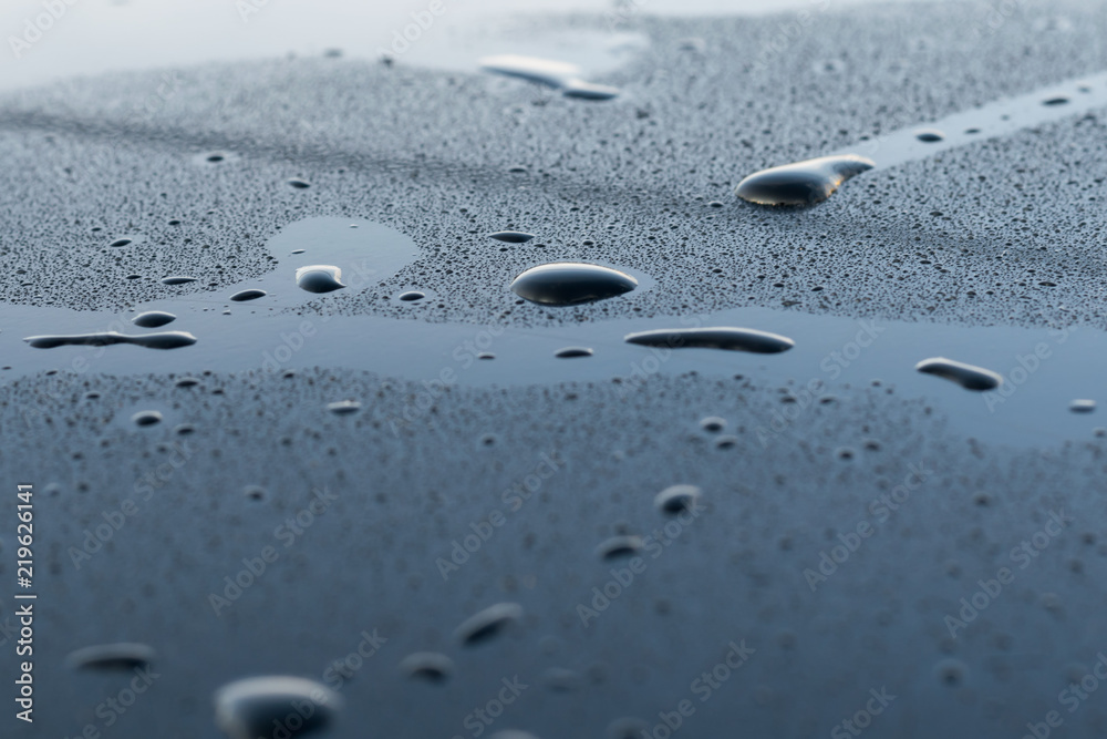 drops of water on a black surface drops of water on a black surface