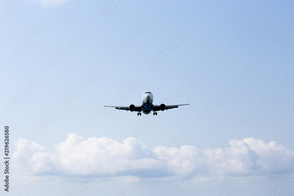 The airplane in the sky goes on landing against a background of white fluffy clouds The airplane in the sky goes on landing against a background of white fluffy clouds