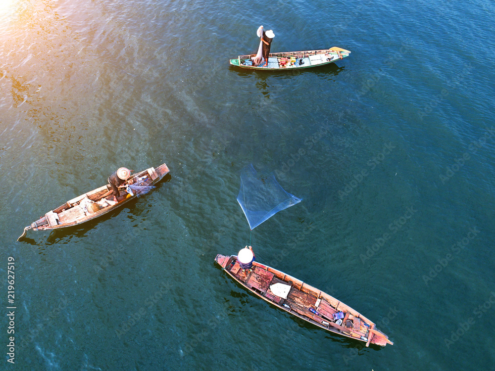 aerial top view of local fishing boats man in group working in throwing  fishing net catching fish in river fresh water lake, to take the life keep  surviving Stock Photo
