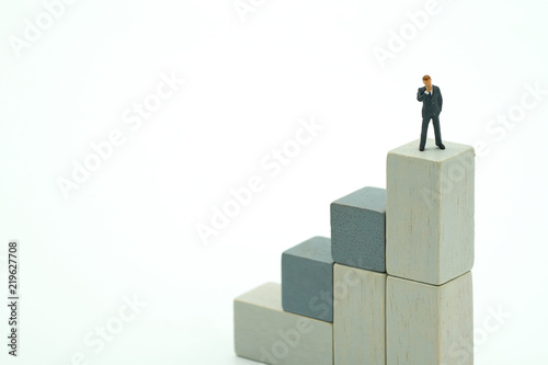Miniature people businessmen standing Investment Analysis Or investment. The concept of being the number one business in the world stands at its peak.