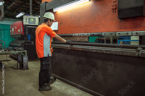 BENDING MACHINE, Metal worker bending machine at work in factory. © tong2530