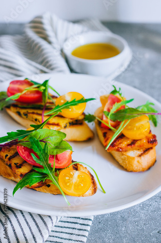 Bruschetta with cherry tomato salad with grilled haloumi cheese, with chard and arugula