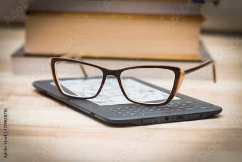 The glasses are lying on the book reader