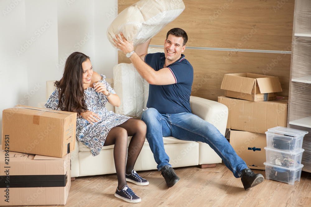 Young happy couple in room with moving boxes at new home.Happiness in their new house Young happy couple in room with moving boxes at new home.Happiness in their new house