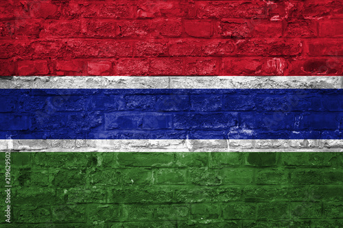 Flag of Gambia over an old brick wall background, surface
