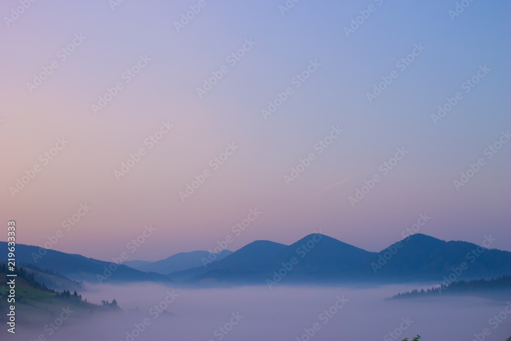 Morning panorama of mountains in the fog