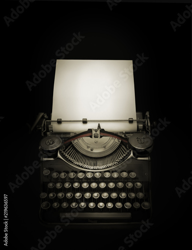 Ancient typewriter against black background in dark ambiance photo