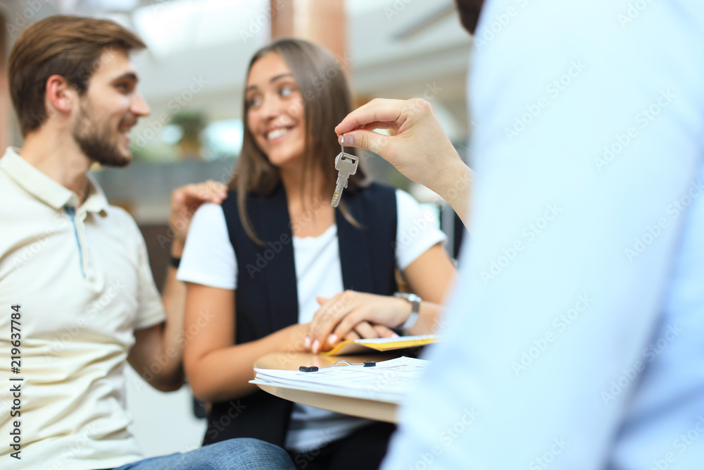 Close up of real estate agent giving keys to couple of customers. Close up of real estate agent giving keys to couple of customers.