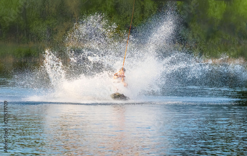Wake Board a man does a trick on the Board on the water splashes © Mariia Petrakova