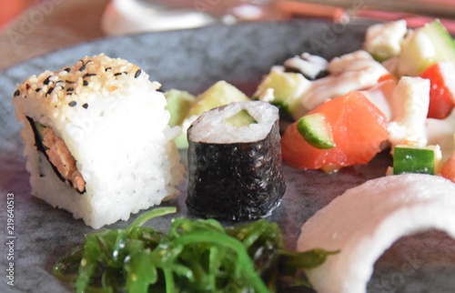 Sushi mit Lachs, Seetang, Gurken und Reis auf einer Platte angerichtet photo