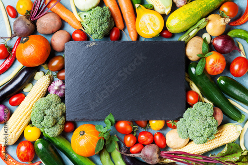 Autumn farm vegetables, root crops and slate cutting board top view with copy space for menu or recipe. Healthy food background. photo