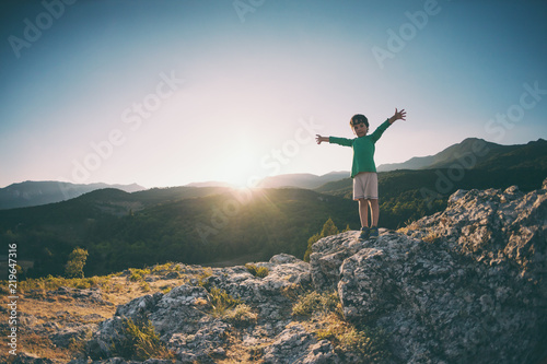 A boy on top of a mountain.