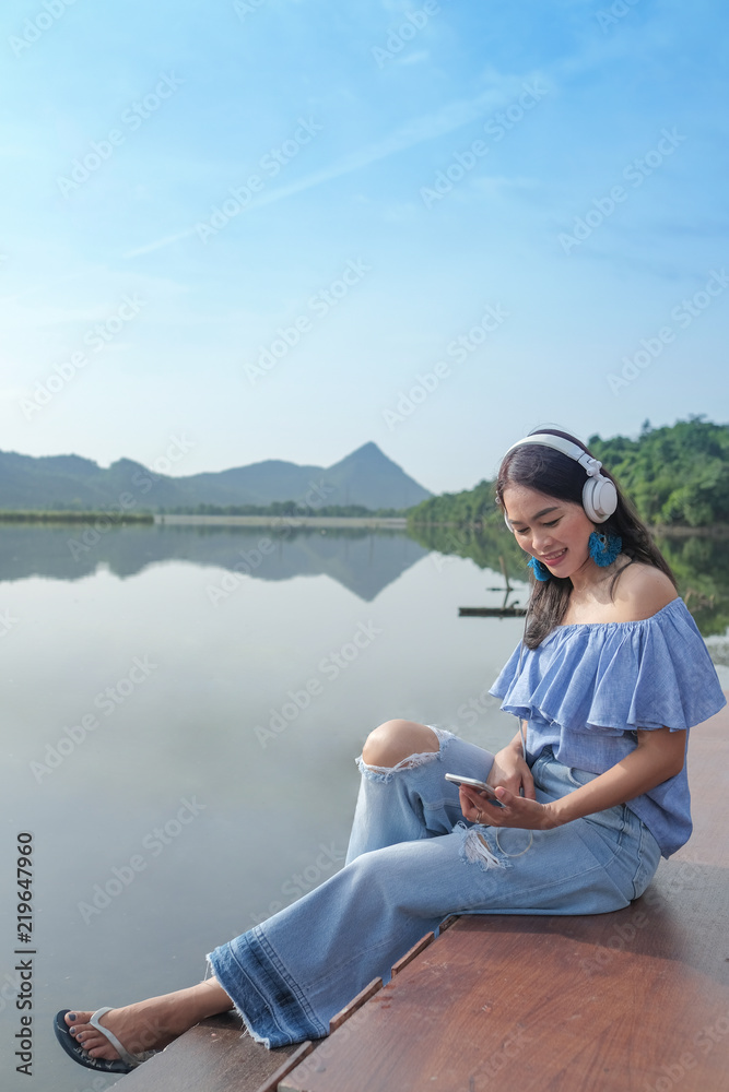 women listening music at the lake.