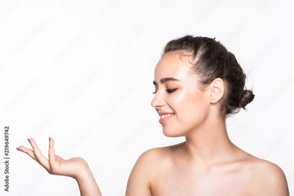 Cute young woman showing empty copy space on the open hand isolated on white background. Female face closeup. Skincare and wellness concept. Presenting your product Cute young woman showing empty copy space on the open hand isolated on white background. Female face closeup. Skincare and wellness concept. Presenting your product